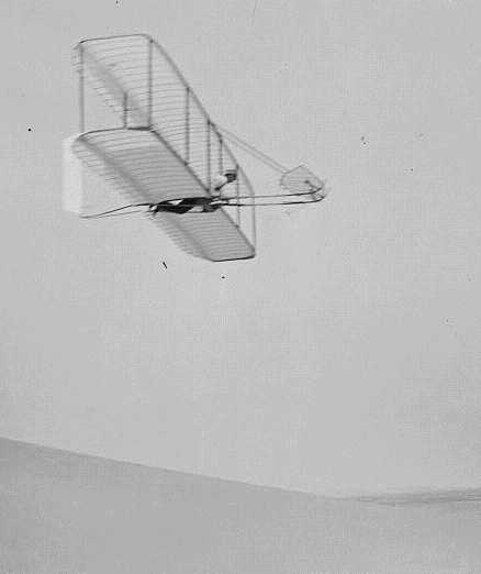 Wilbur Wright pilots the 1902 glider over the Kill Devil Hills, October 10, 1902. The single rear rudder is steerable; it replaced the original fixed double rudder